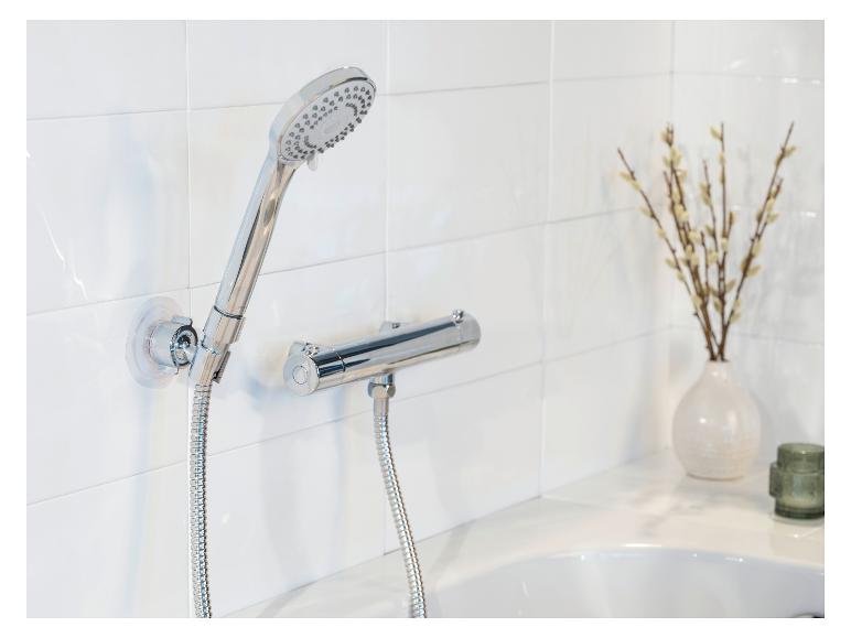 Ensemble de douche chromé moderne fixé à un mur de carrelage blanc.