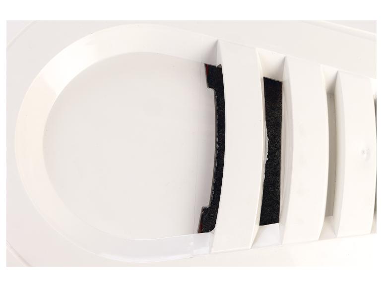 Gros plan d'une grille de ventilation blanche avec un matériau filtrant foncé visible derrière les lamelles.