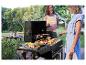 Grillades estivales : saucisses, brochettes et poulet sur un barbecue noir.