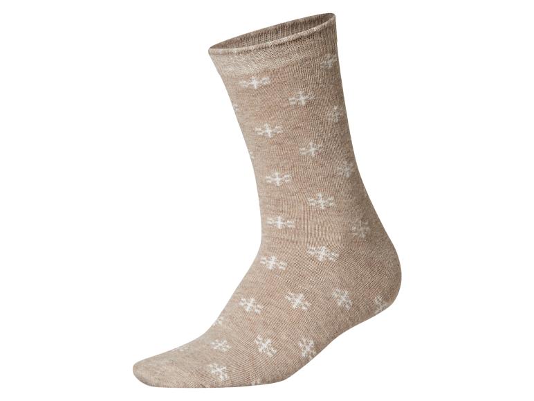 Chaussette beige avec des motifs de flocons de neige blancs.