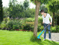 Une femme utilise une débroussailleuse Bosch pour désherber son jardin.