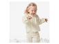 Bébé portant un ensemble pantalon et haut crème.