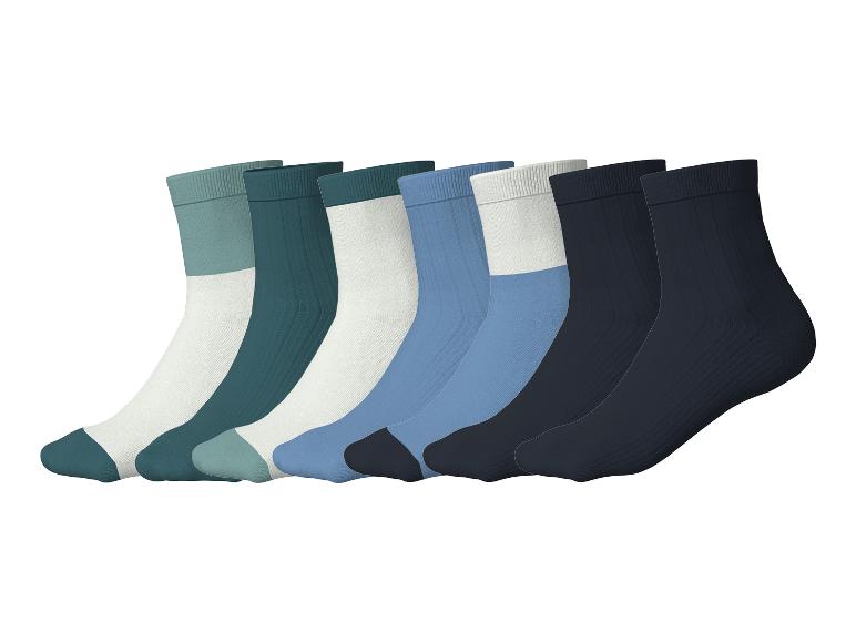 Sept paires de chaussettes colorées disposées en diagonale sur fond blanc.
