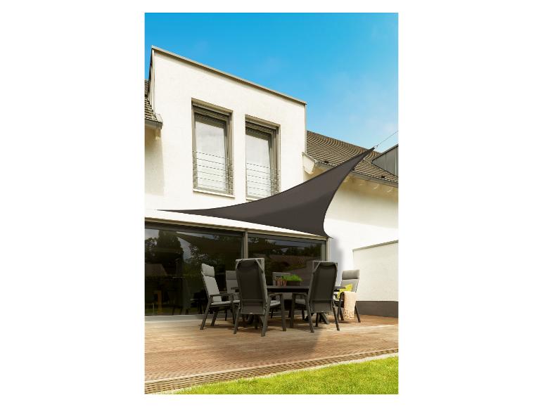 Terrasse avec plancher en bois, mobilier d'extérieur et voile d'ombrage marron.