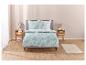 Un lit avec un ensemble de draps blanc et bleu à motifs de feuilles