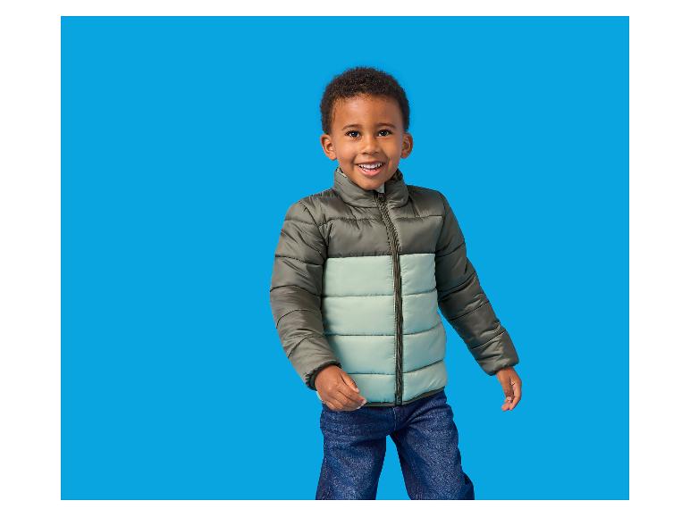 Garçon souriant en doudoune bicolore et jean
