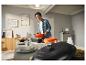 Un homme apporte une cocotte en fonte orange SILVERCREST® sur une table dressée.