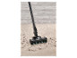 Un aspirateur nettoie un tapis.