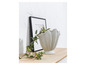 Un vase blanc en forme de fleur avec une plante sur une surface en bois
