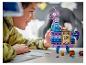 Un garçon sourit à un lama LEGO Fortnite violet et bleu.