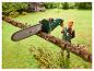 Un homme utilise une tronçonneuse Parkside pour tailler une branche d'arbre dans un jardin.