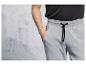 Homme portant un pantalon de survêtement gris avec des cordons noirs.