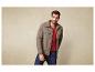 Homme portant une veste vert foncé et un t-shirt rouge.