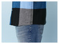 Un homme portant une chemise à carreaux bleus et un jean.