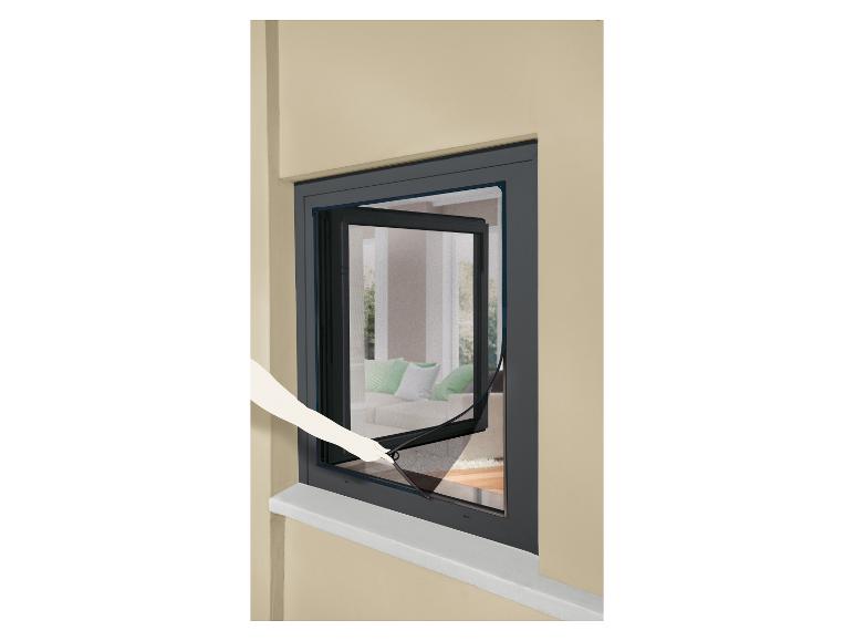 Moustiquaire ouverte sur une fenêtre, avec une main qui la tire