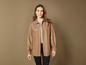 Une femme portant une chemise en cuir marron.