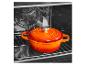 Cocotte en fonte orange dans un four.
