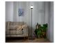 Un lampadaire noir avec un abat-jour en verre dans un salon.