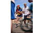 Deux personnes en tenue de sport colorée, bob, t-shirts, shorts, chaussettes et claquettes, acclamant.
