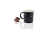Une tasse noire avec un imprimé de constellation et deux barres chocolatées.