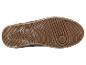 La semelle d'une chaussure de sport marron avec une bande de roulement épaisse.
