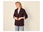 Femme souriante en blazer bordeaux texturé, t-shirt blanc et jean clair.
