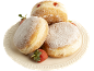 Beignets moelleux saupoudrés de sucre glace et de confiture, avec des fraises fraîches sur un plat.