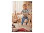 Un bébé joue avec un portique en bois pour jouets suspendus.