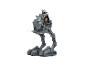 Une figurine d'action Mandalorian avec Grogu chevauchant un jouet AT-ST walker.