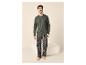 Homme souriant en pyjama à manches longues et pantalon à carreaux, pieds nus.