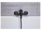 Un robinet de salle de bain noir avec une pomme de douche sur une baignoire blanche.