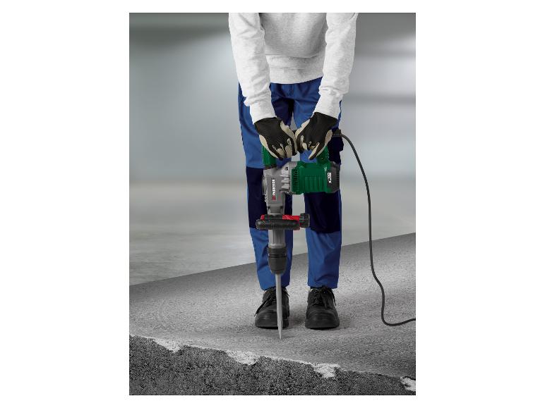 Homme avec marteau-piqueur électrique cassant du béton