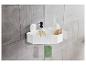Une étagère d'angle blanche dans la douche avec du shampoing, une brosse et une éponge.