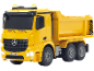 Camion-benne jouet jaune avec phares allumés sur fond noir