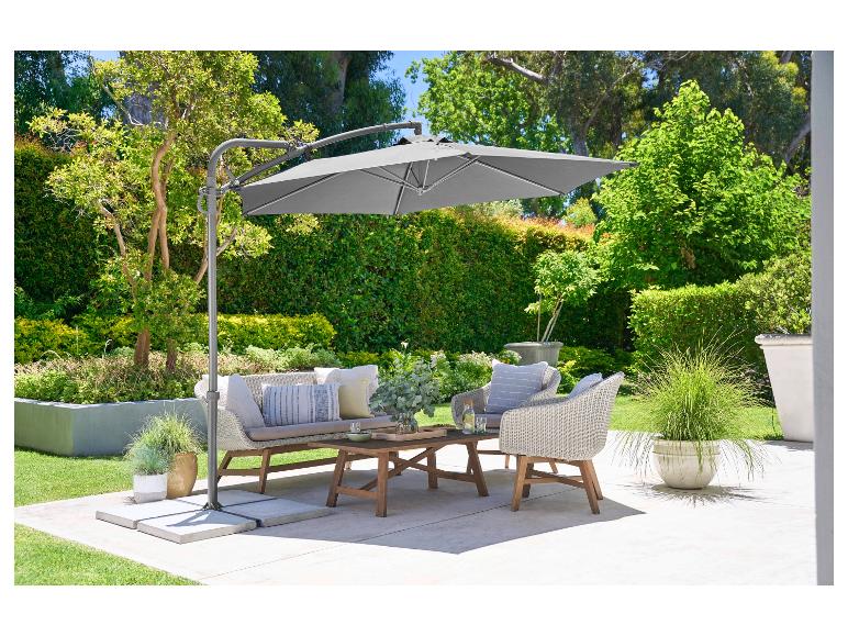 Parasol de jardin, salon de jardin en osier et table basse.
