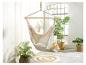 Hamac beige en toile, plantes tropicales et tapis rond tressé créent une ambiance bohème.