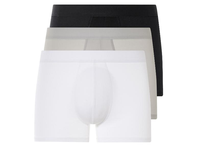 Trois paires de boxers en blanc, gris et noir.