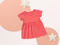 Une robe rose pour bébé avec des peluches en forme d'étoile.