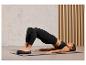 Une femme fait un exercice sur un tapis de yoga avec un coussin d'équilibre.