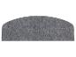 Un paillasson gris, incurvé et de forme de tapis.