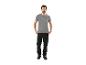 Homme en t-shirt gris avec un imprimé géométrique et un pantalon de travail noir.