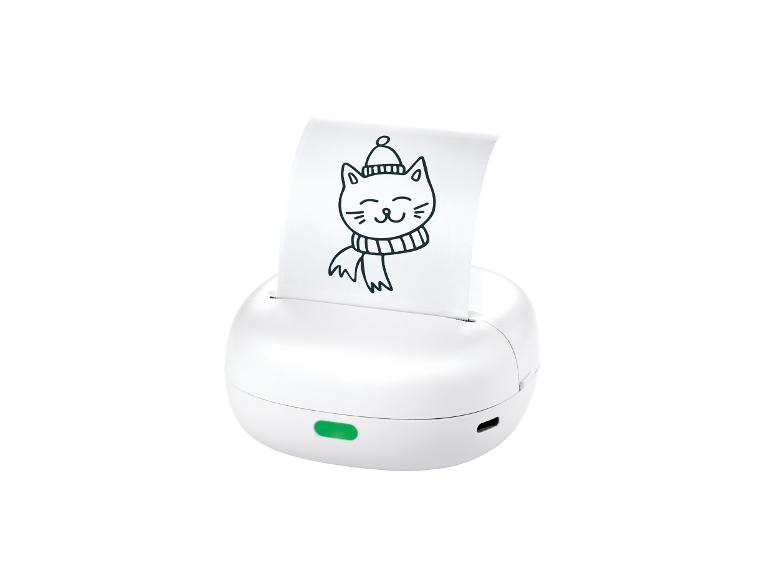 Imprimante portable blanche avec papier imprimé montrant un dessin de chat avec bonnet et écharpe.