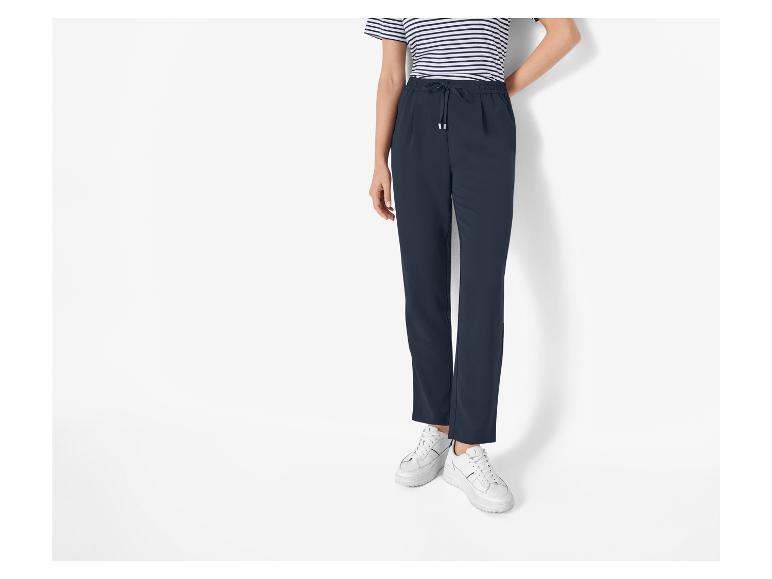 Pantalon bleu marine avec cordon de serrage et baskets blanches.