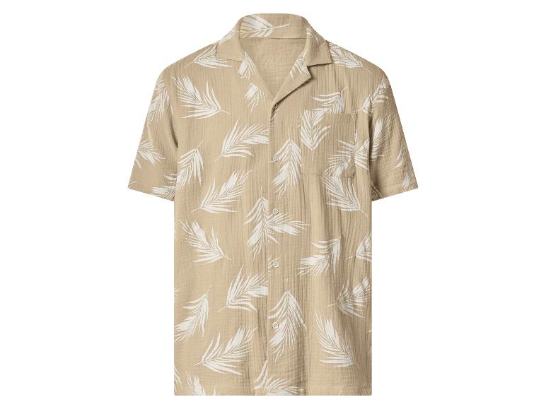 Chemise beige à manches courtes avec imprimé feuilles de palmier blanches.