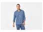 Homme souriant en chemise bleue à manches longues et jean.