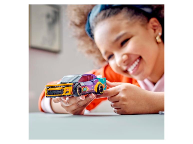 Un enfant tient un LEGO Speed Champions Chevrolet Camaro.