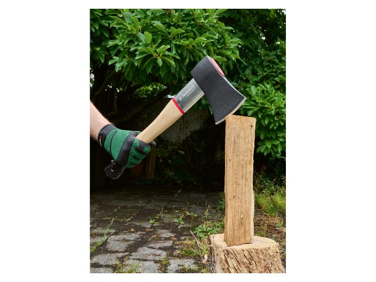 Personne gantée de vert tenant une hache Parkside Performance prête à fendre du bois