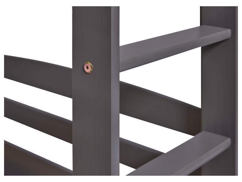 Détail d'un lit en bois gris foncé.