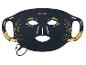 Masque facial LED noir avec des détails dorés de cils et de feuilles, avec un câble de charge.
