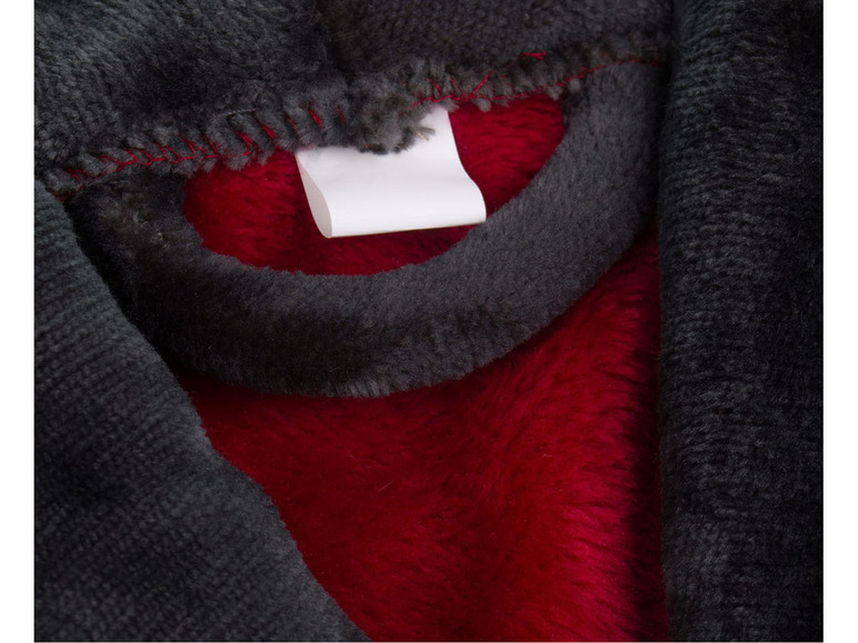 Gros plan d'une veste polaire noire et rouge avec une étiquette blanche.